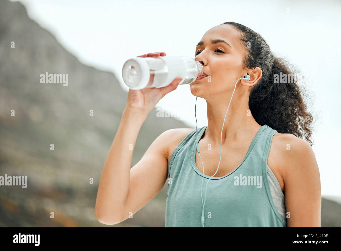Eine Pause zum Hydrat machen. Eine junge Frau, die eine Pause vom Ausarbeiten, um Wasser zu trinken. Stockfoto