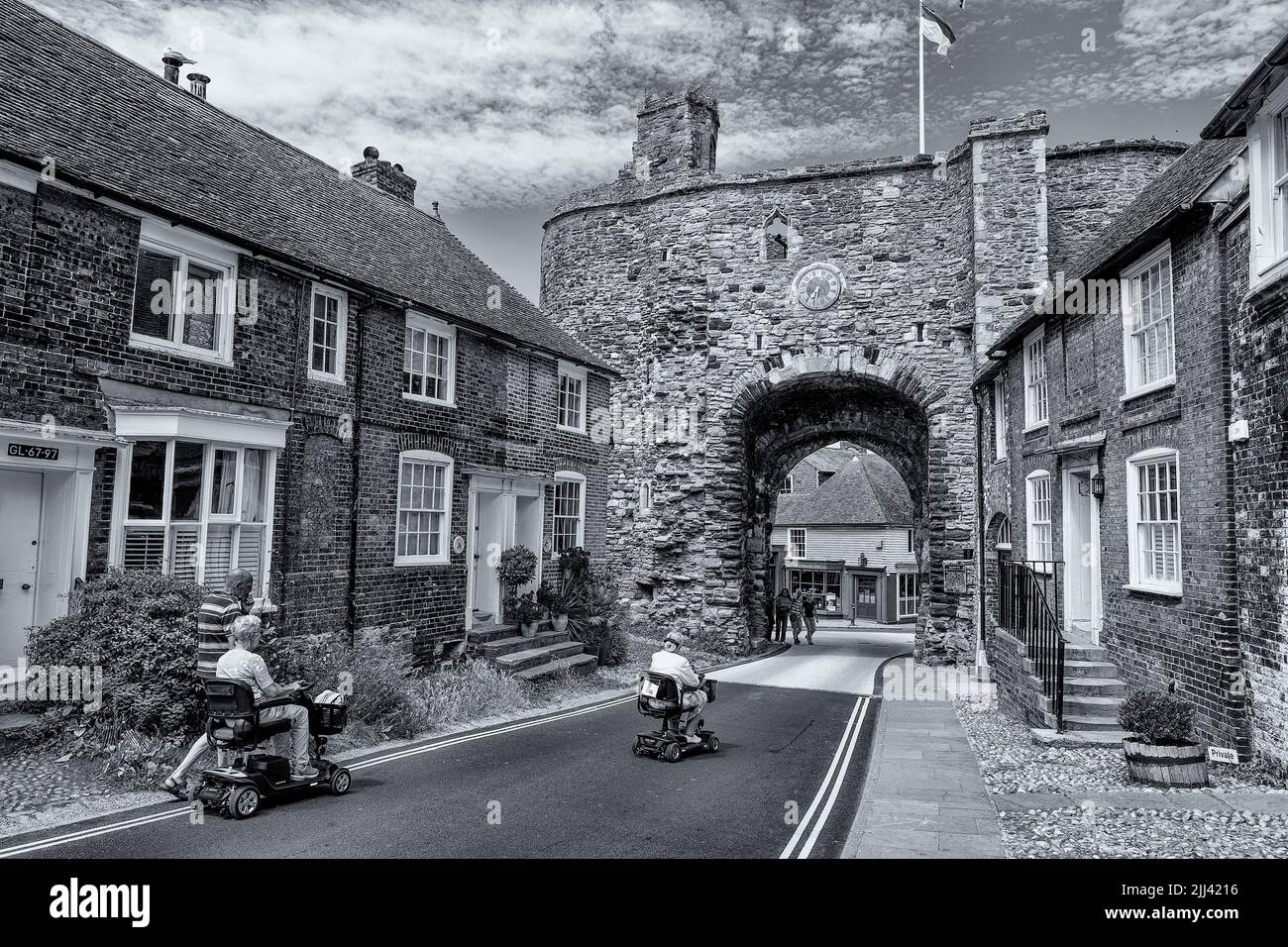 Zwei Mobilitätsroller werden zum Landgate-Bogen in Rye, East Sussex, gefahren Stockfoto