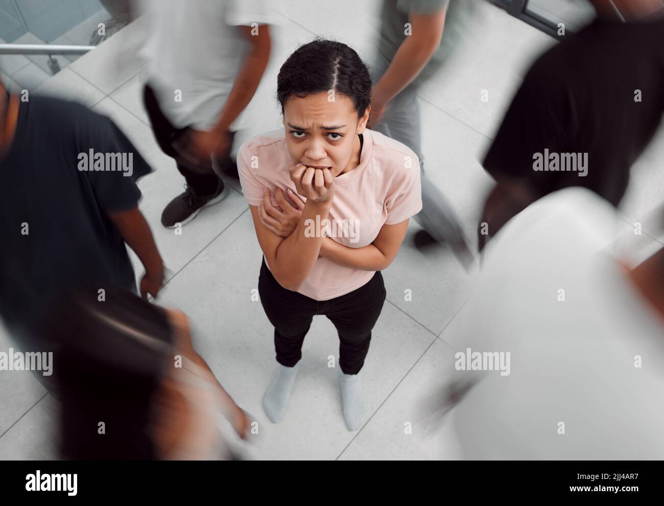 Im Namen der Verzweiflung. Eine junge Frau, die eine psychische Erkrankung erlebt, während sie von Menschen umgeben ist. Stockfoto