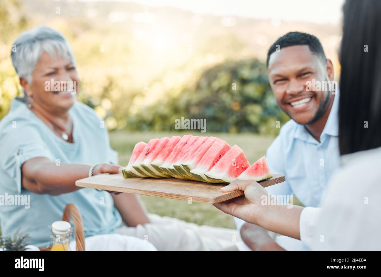 Geben Sie unseren Kindern den Wert der Empathie weiter. Ein Vater und ein Sohn genießen Wassermelone bei einem Picknick. Stockfoto