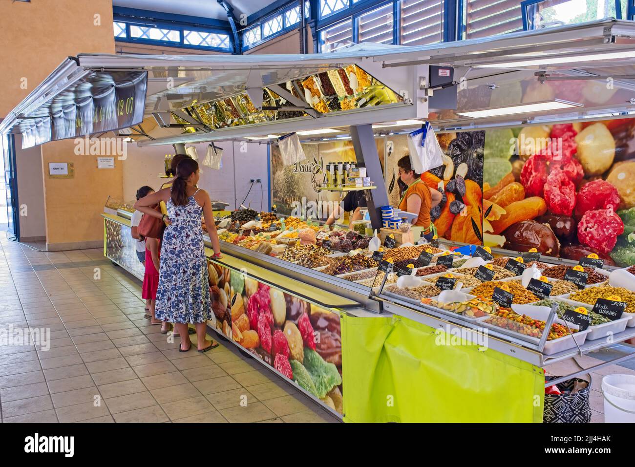 Limousux Aude France 07.22.22 Indoor-Marktstand mit getrockneten Früchten und Nüssen. Junge Frauen in Sommerkleidern. Farbenfrohe Bilder der Produk Stockfoto