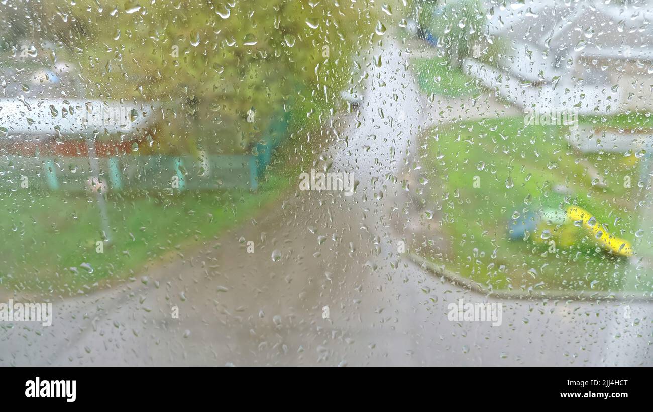 Regentropfen fallen auf stark bemalte Fenster und fließen nach unten Stockfoto