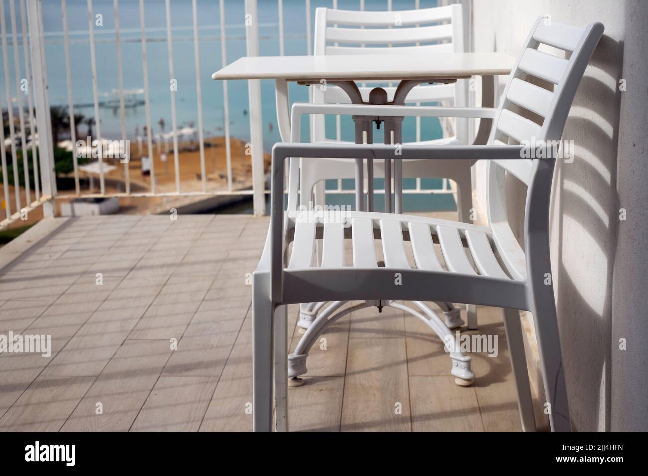 Plastikstühle und -Tisch auf dem Balkon des Hotels oder der Wohnung, Sonnentag aufgenommen Stockfoto