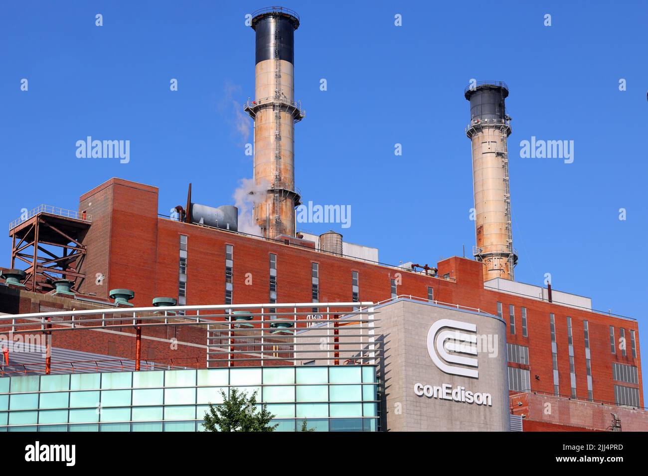 Die Con Edison East River Generating Station mit zwei Stahlstapeln vor einem sonnigen Himmel. Con Ed, Consolidated Edison in Manhattan, New York. Stockfoto