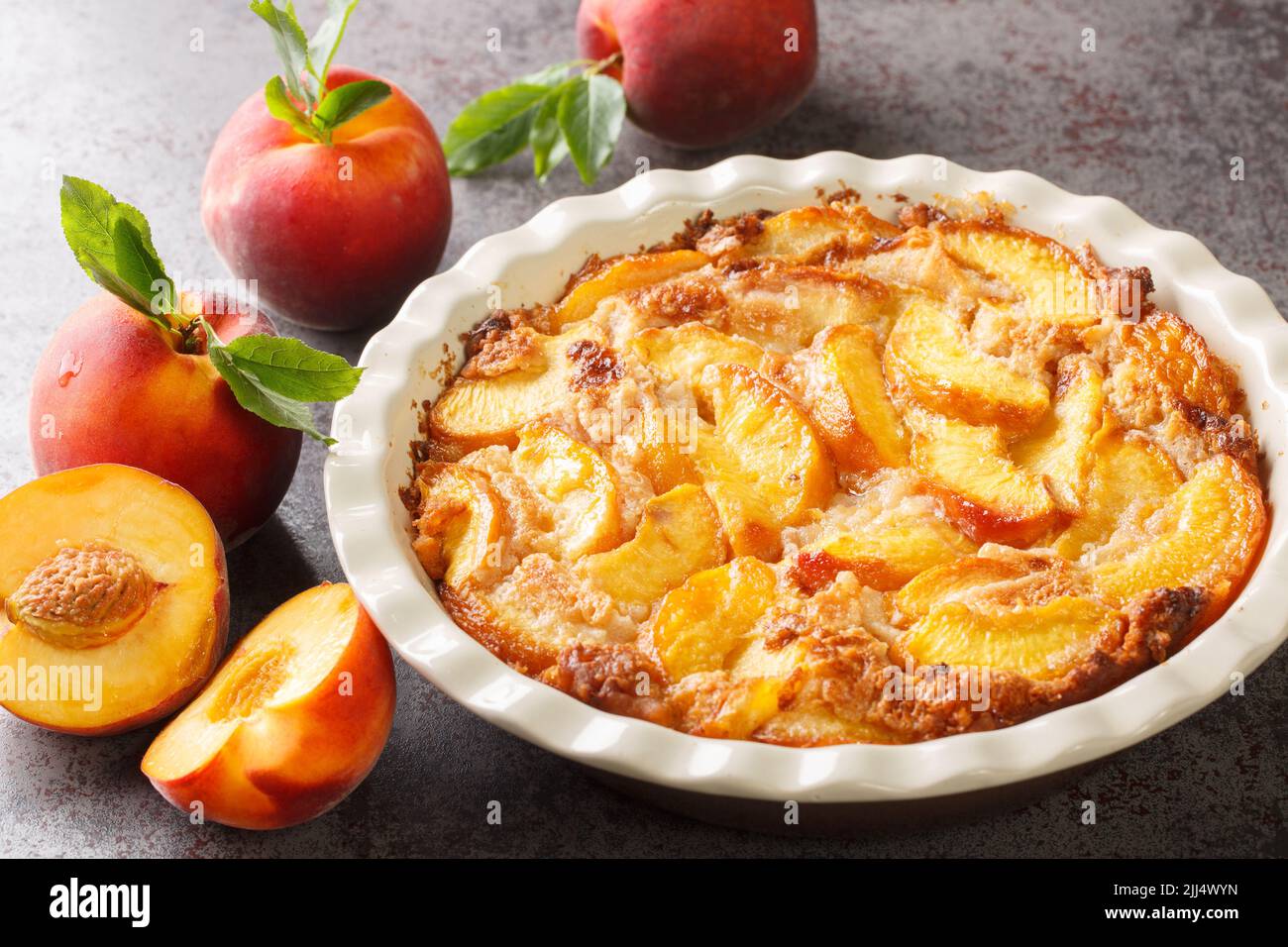 Im Ofen gebackene perfekte Southern Dessert Peach Cobbler auf betongrauem Hintergrund. Horizontal Stockfoto