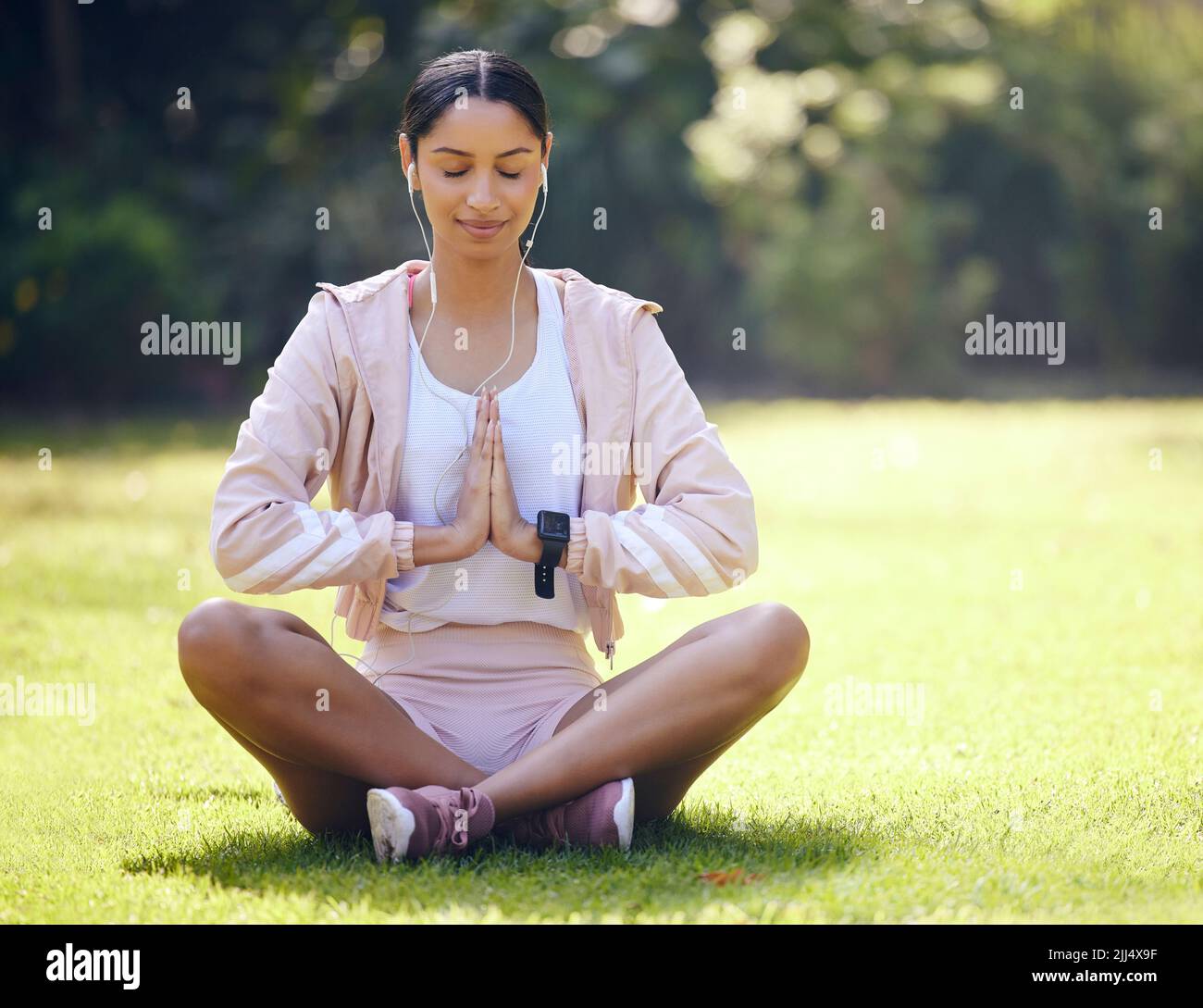 Frieden ist erreichbar durch Fokus. Eine sportliche junge Frau meditiert beim Sport im Freien. Stockfoto