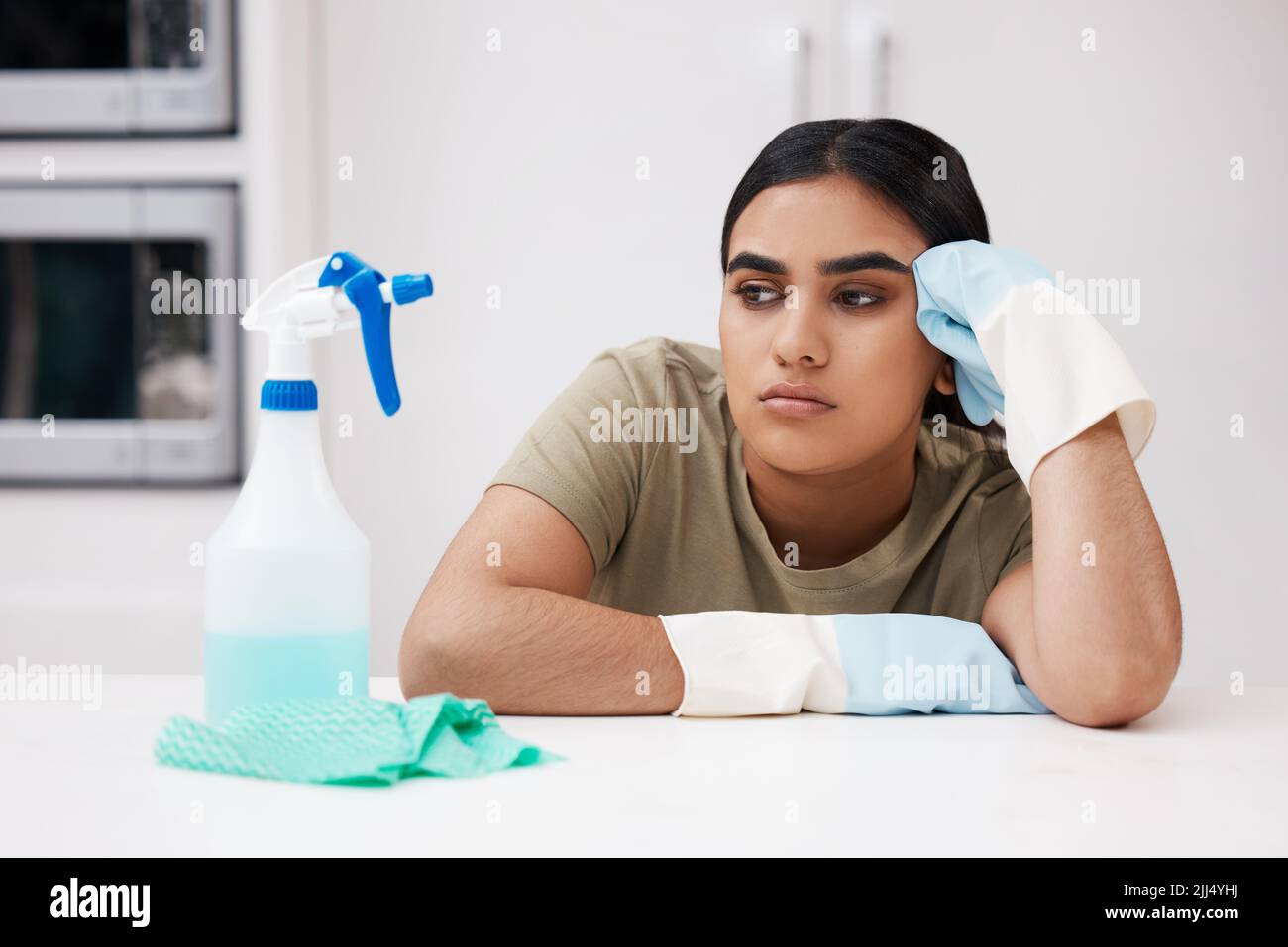 Urgh, ich bin darüber. Eine junge Frau, die beim Putzen gelangweilt aussieht. Stockfoto