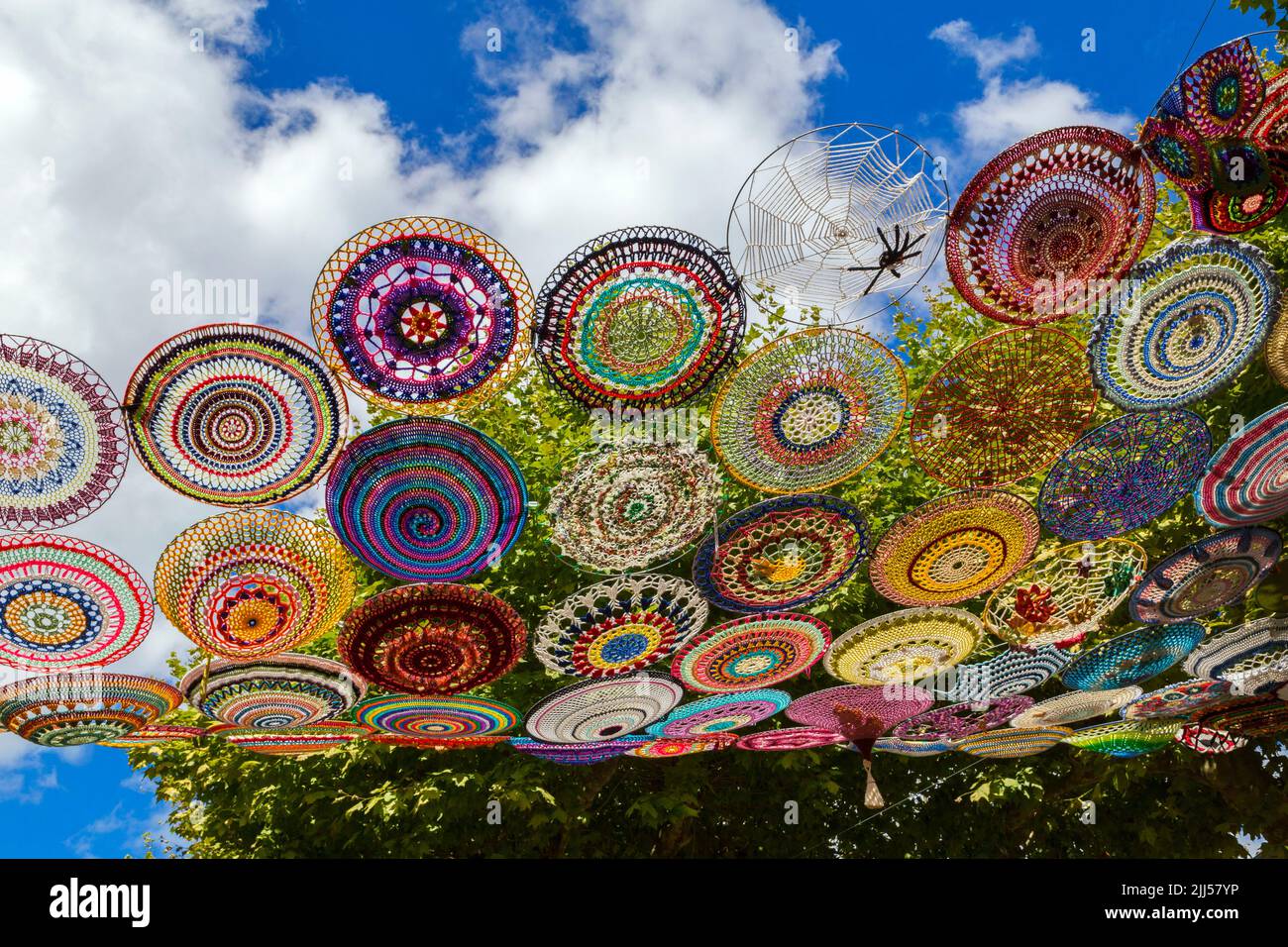 Dekoration der Stadt mit gehäkelten Kreisen für das Musikfestival „Chalabre en Serenade“. Nach einer Idee der amerikanischen Gruppe 'The Riverbend Yarn Bombers', die in Illinois, Mississippi, lebt. Die Arbeit von Julie Prochowski wird von einem Team von vierzig Damen aus Chalabre und der ganzen Welt begleitet. Chalabre, Österreich, Frankreich Stockfoto