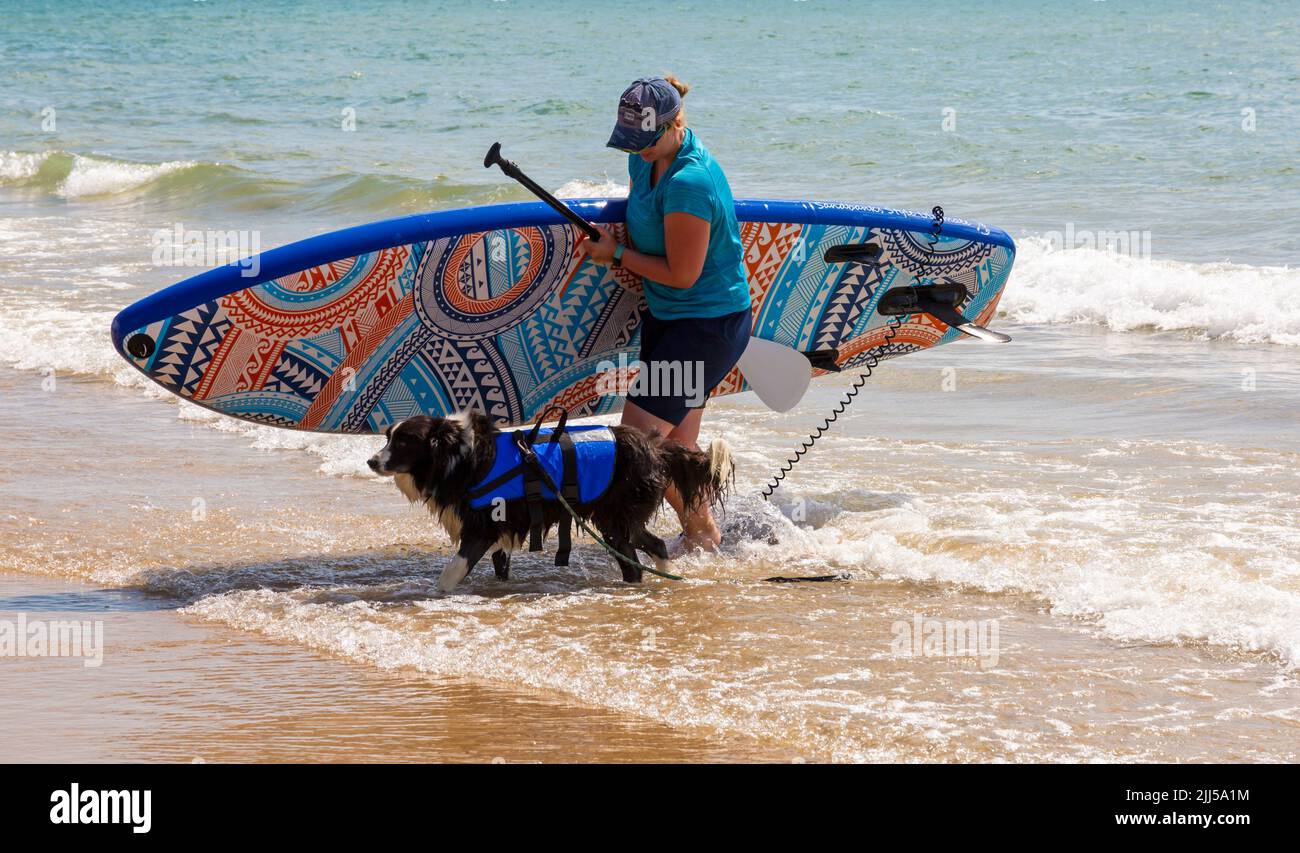 Branksome Dene Chine, Poole, Dorset, Großbritannien. 23.. Juli 2022. Das von Shaka Surf organisierte Dog Surfing Championships Dog Masters Festival in Großbritannien findet am Strand von Branksome Dene Chine statt. Britains einziger Surf-Wettbewerb für Hunde, jetzt im vierten Jahr, ist größer als je zuvor, mit 30 Hundekonkurrenten, die für ein rasantes doggy Paddleboard-Rennen registriert sind, sowie Hundebesitzern ähnelichem Kostümwettbewerb, Mutts Market, Paw Inn Beach Bar, Hundeschau, Essen und mehr, Mit Live-Musik bis in den Abend. Quelle: Carolyn Jenkins/Alamy Live News Stockfoto