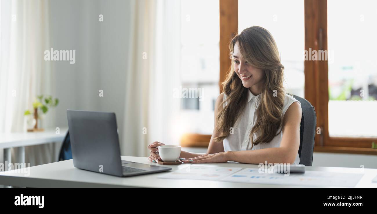 Glückliche asiatische Frau sitzen am Tisch beschäftigt in der persönlichen Spesenverwaltung, verwenden Sie Rechner berechnen Haushaltsgeräte, Rechnungen bezahlen durch sichere E-Banking Stockfoto