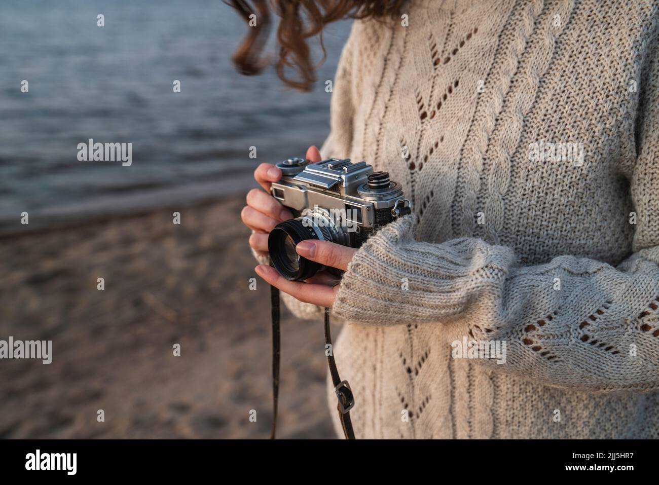 Junge Frau trägt einen Pullover mit Kamera Stockfoto