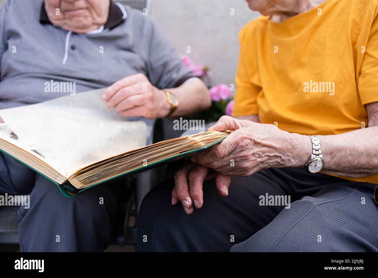 Ältere Frau mit Mann, der das Fotoalbum ansieht Stockfoto