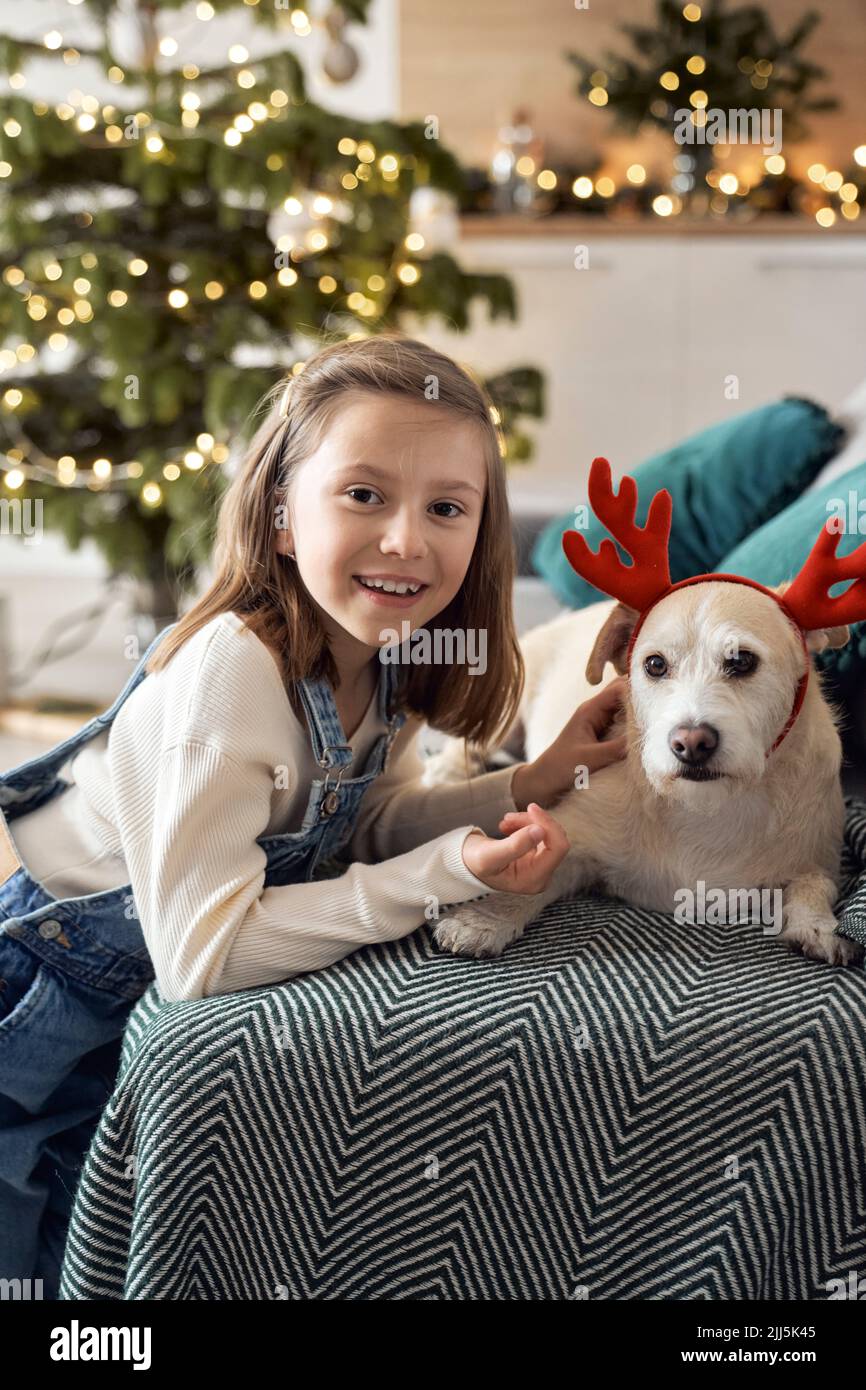 Glückliches Mädchen mit Hund im Wohnzimmer Stockfoto