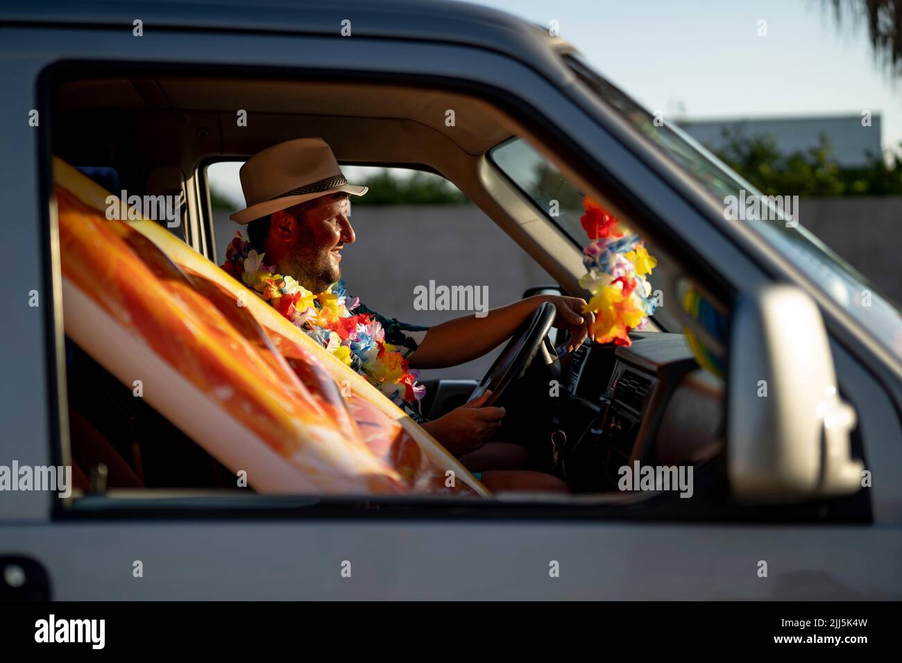 Lächelnder reifer Mann mit Poolfloß im Auto Stockfoto