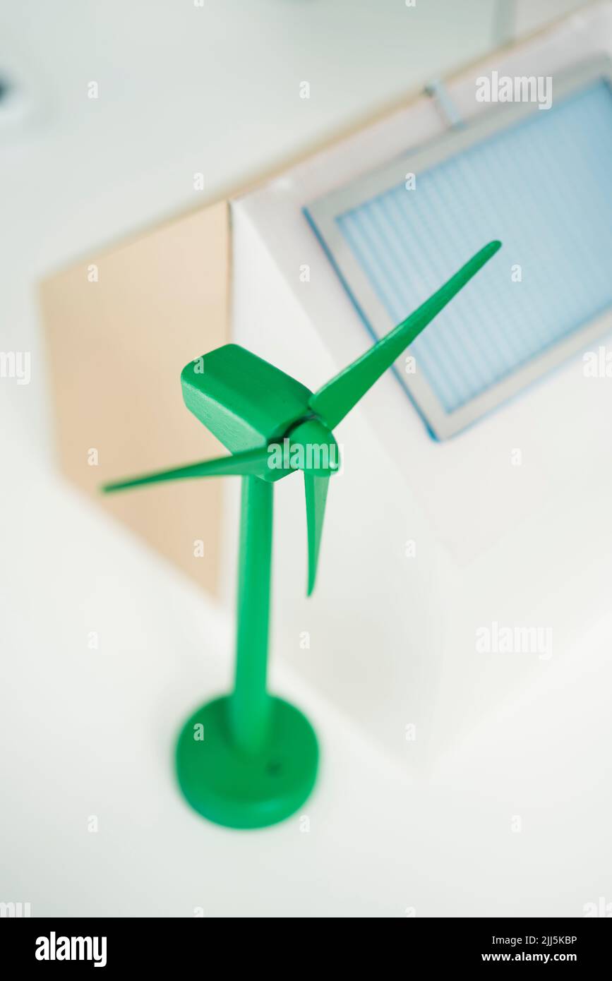 Modell der Windturbine und Haus mit Solarpanel am Arbeitsplatz Stockfoto