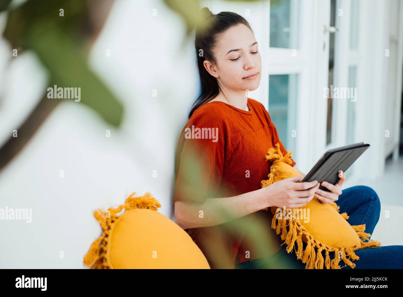 Frau, die einen Tablet-PC im Wohnzimmer zu Hause verwendet Stockfoto