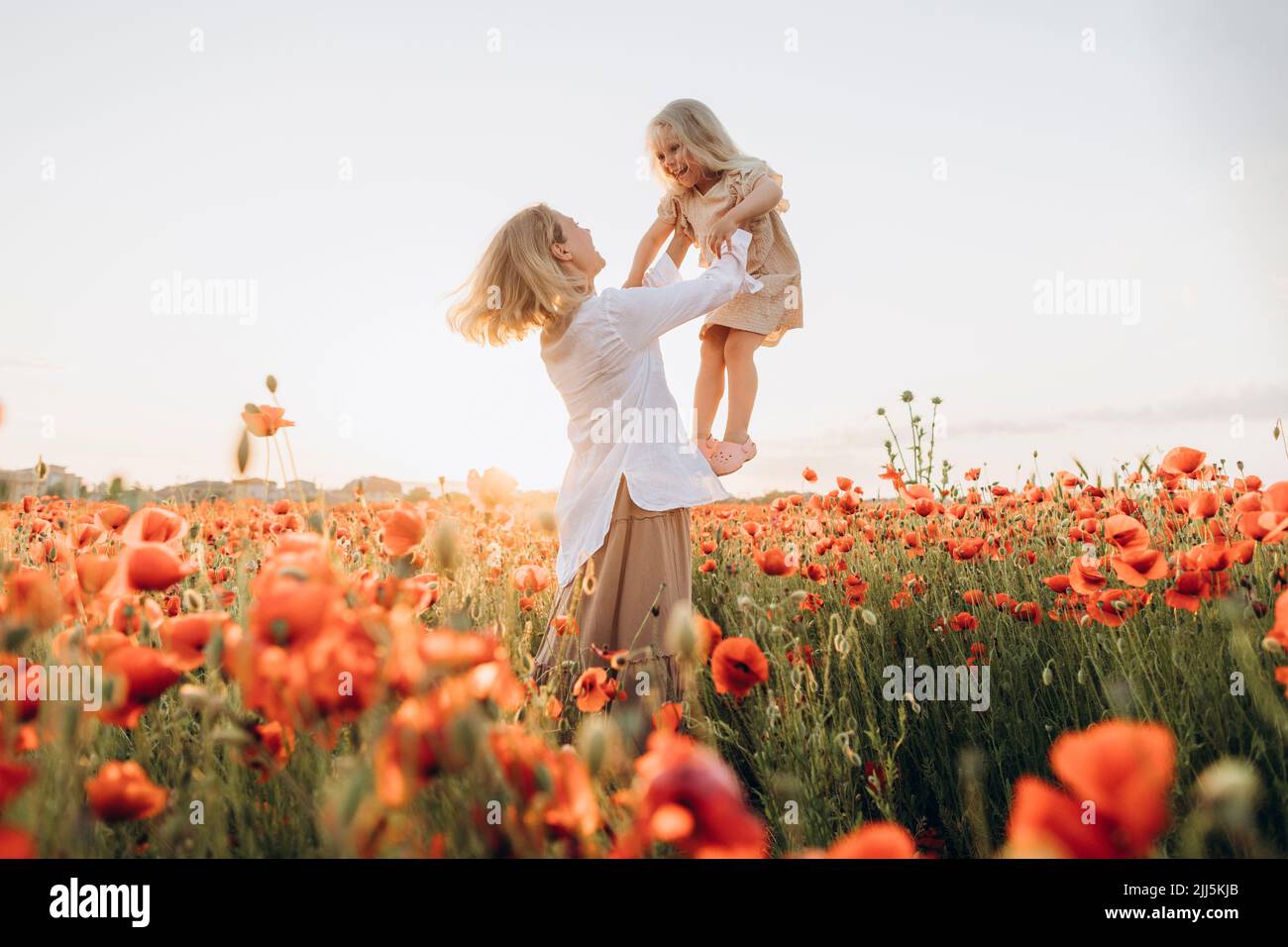 Glückliche Mutter, die ihre Tochter in die Luft hob Stockfoto