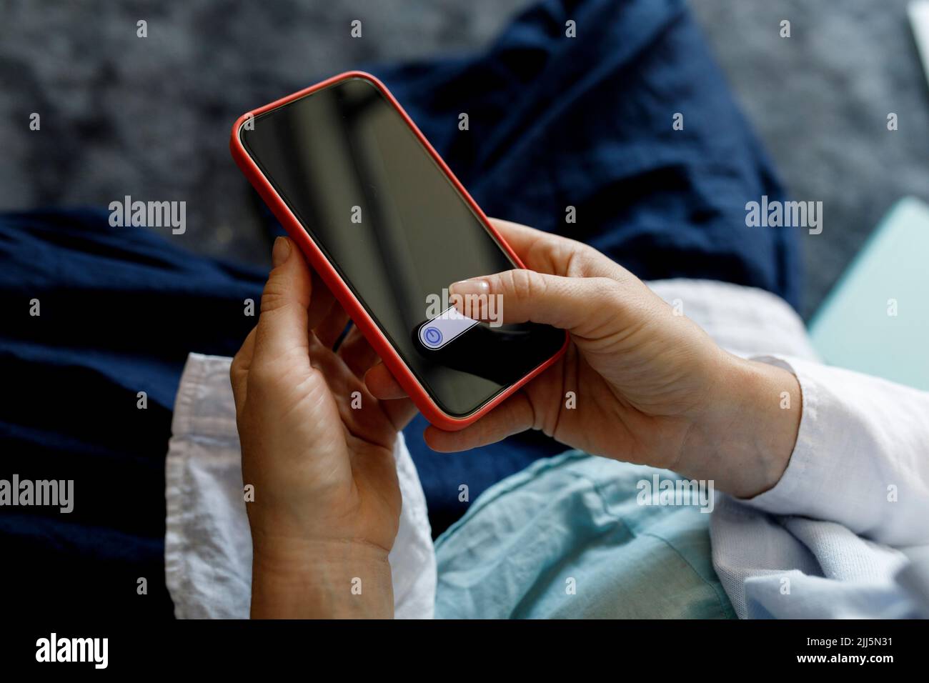 Frau schaltet Smartphone zu Hause aus Stockfoto