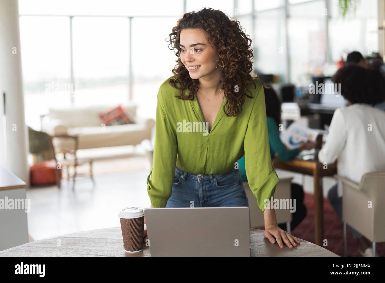 Geschäftsfrau mit Laptop am Tisch im Büro Stockfoto