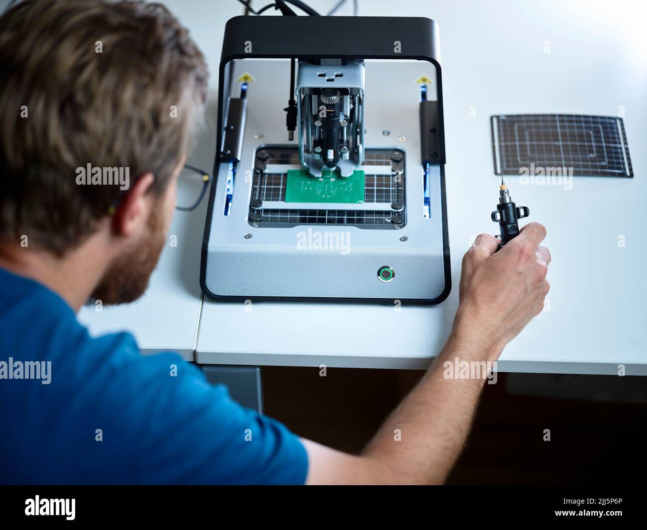 Techniker mit Blick auf Fräsmaschine Schneidebrett im elektronischen Labor Stockfoto