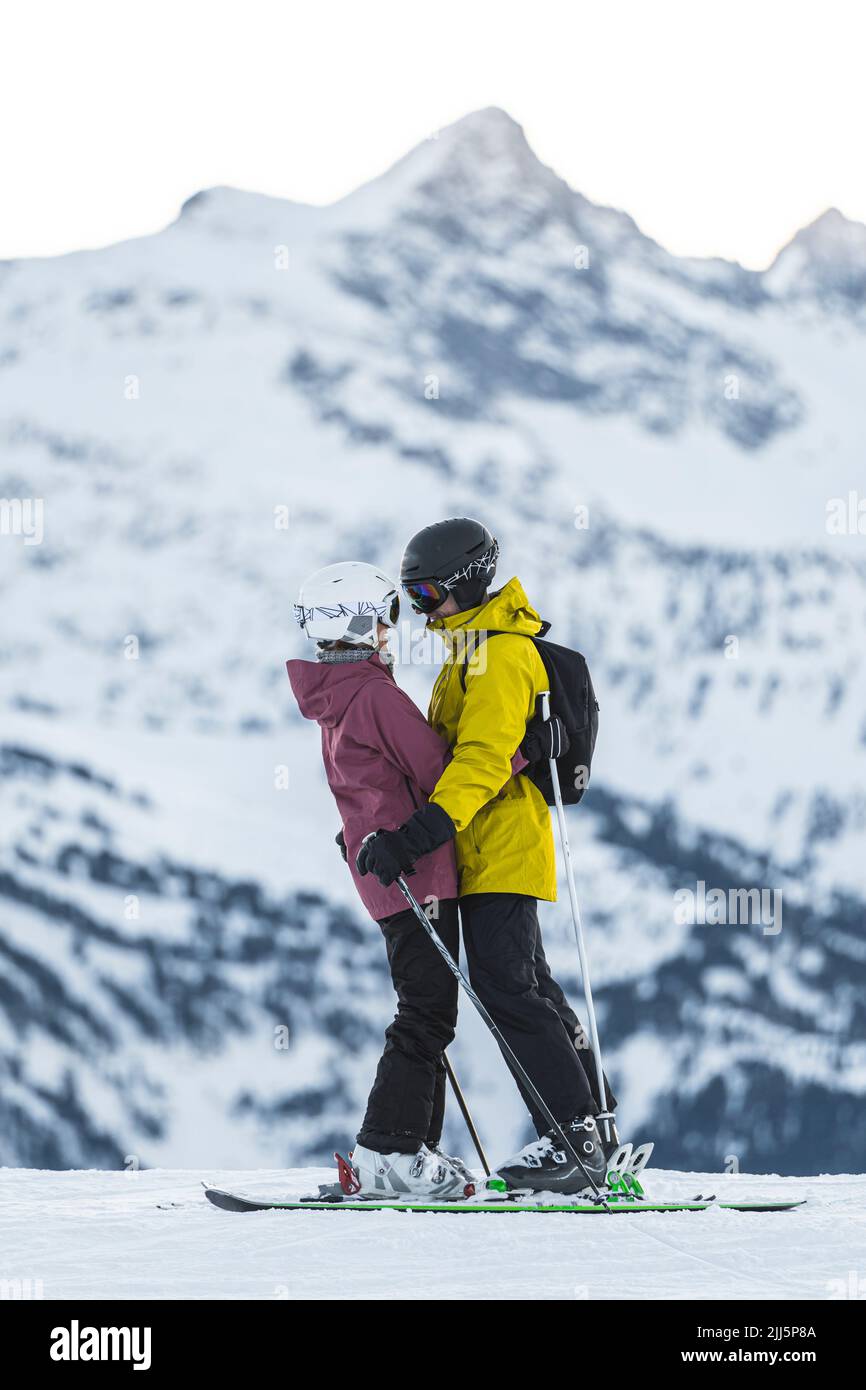 Romantisches Paar in Skibekleidung umarmt im Baqueira Beret Resort, Pyrenäen, Spanien Stockfoto
