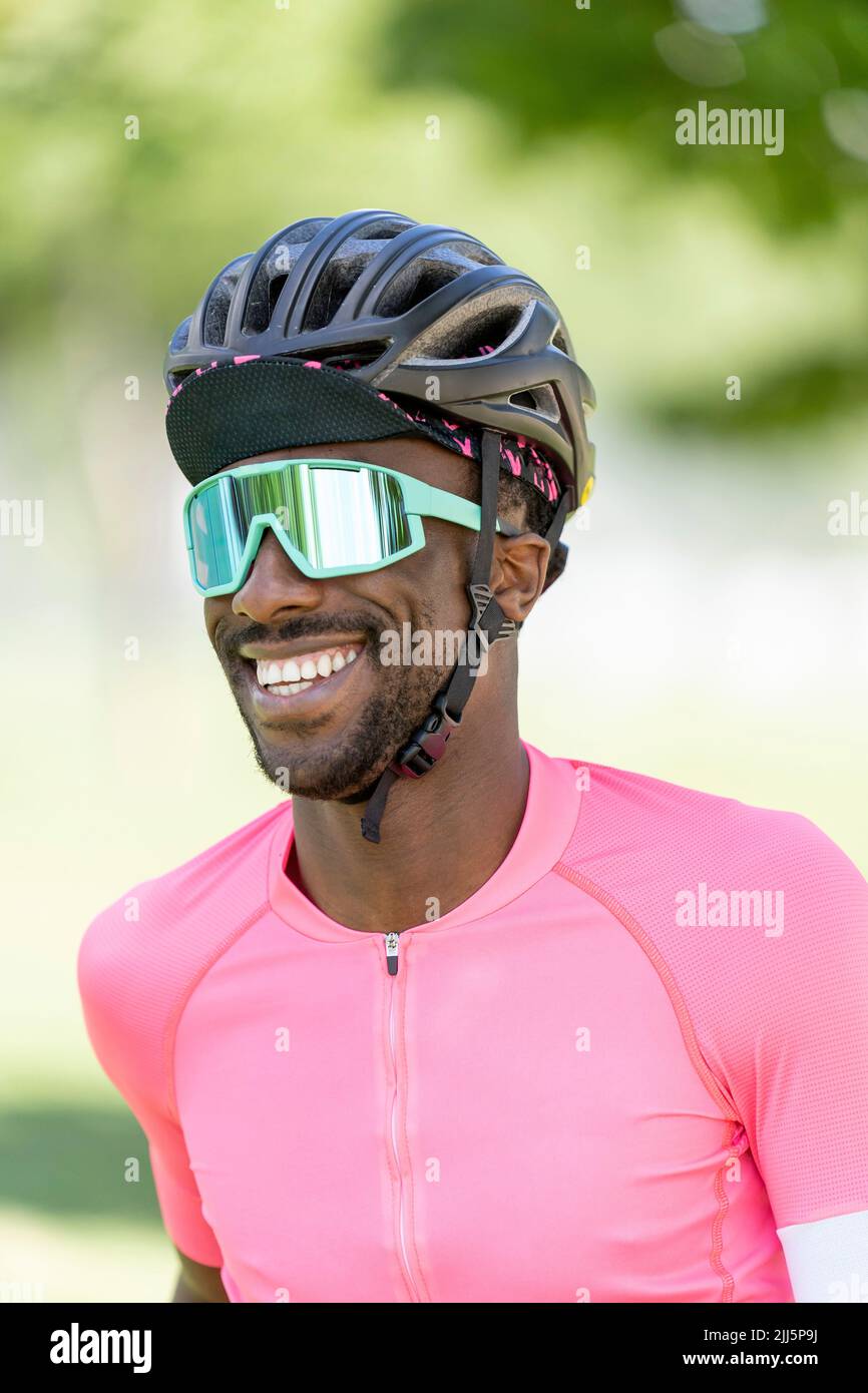Lächelnder Mann mit Fahrradhelm und Sonnenbrille Stockfoto