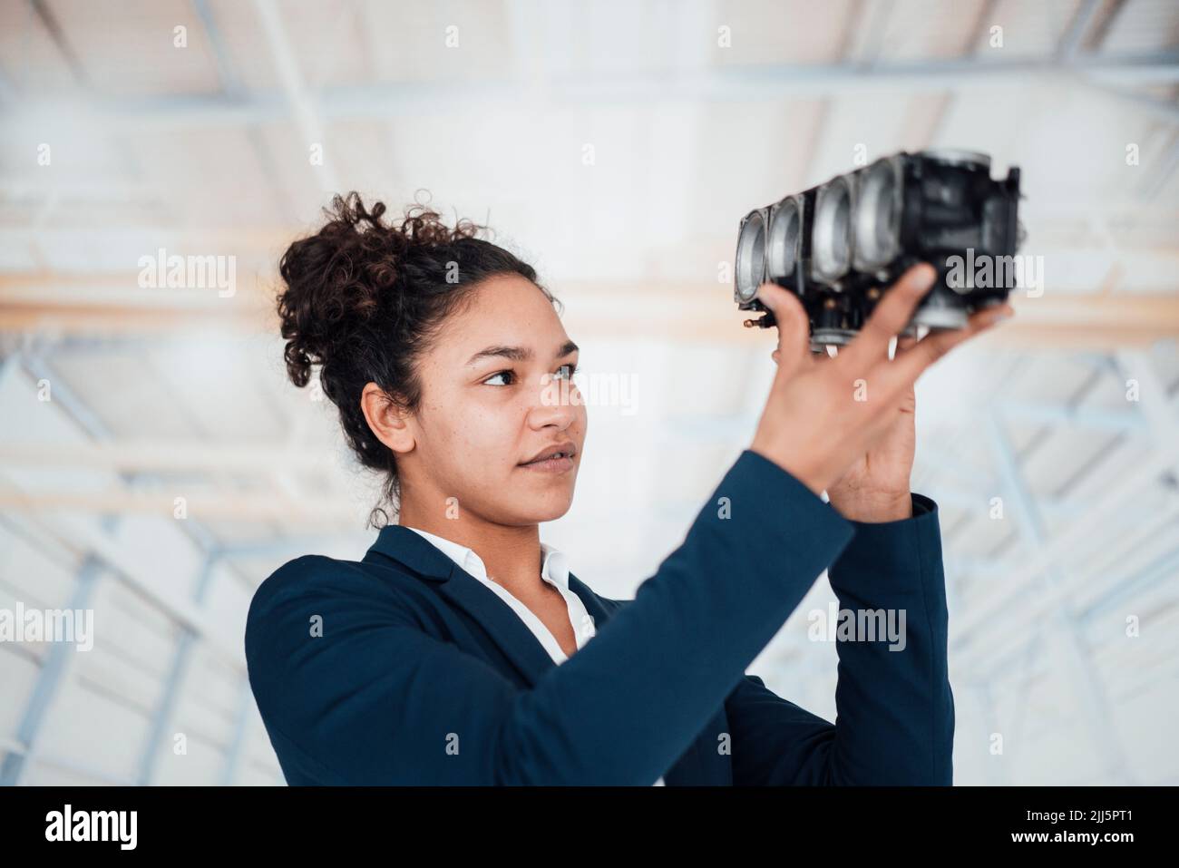 Junge Geschäftsfrau untersucht Beleuchtungsausrüstung Stockfoto