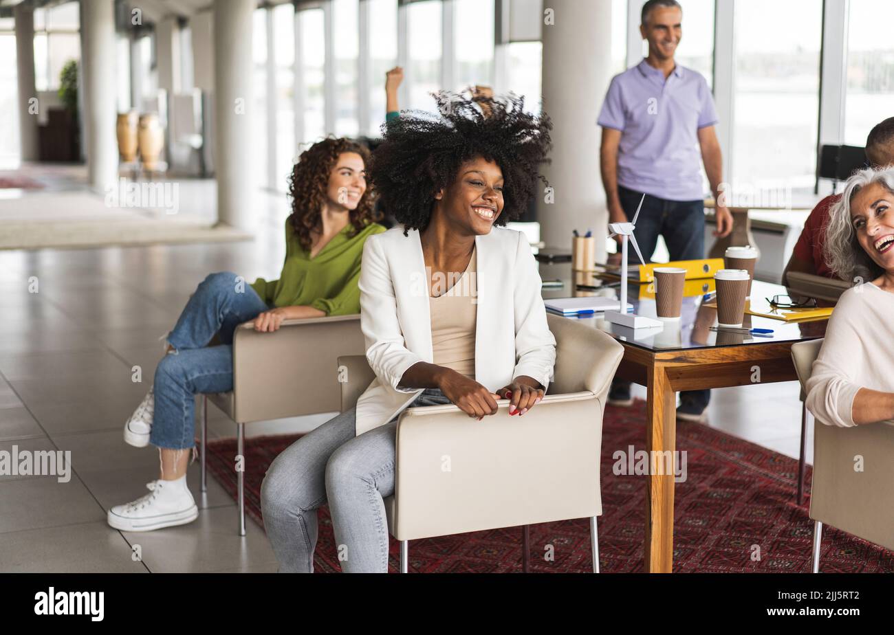 Glückliche Geschäftskollegen sitzen im Büro zusammen Stockfoto