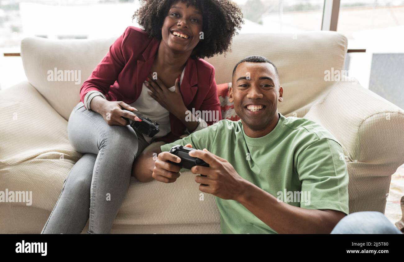 Glückliche junge Frau spielt Videospiel mit Mann Stockfoto