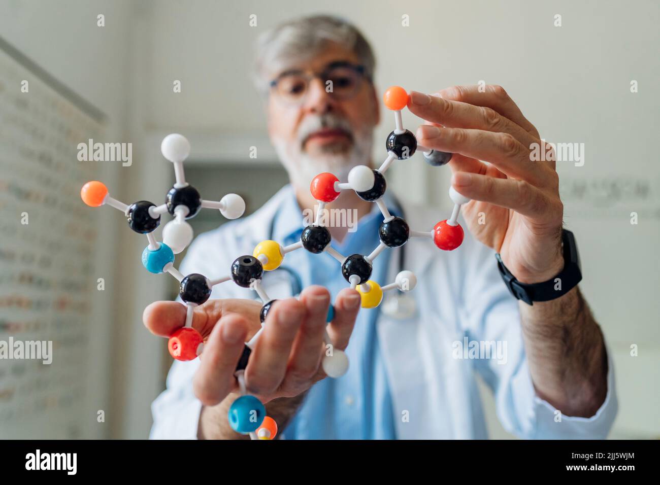 Reifer Wissenschaftler mit Helix-Modell im Labor Stockfoto