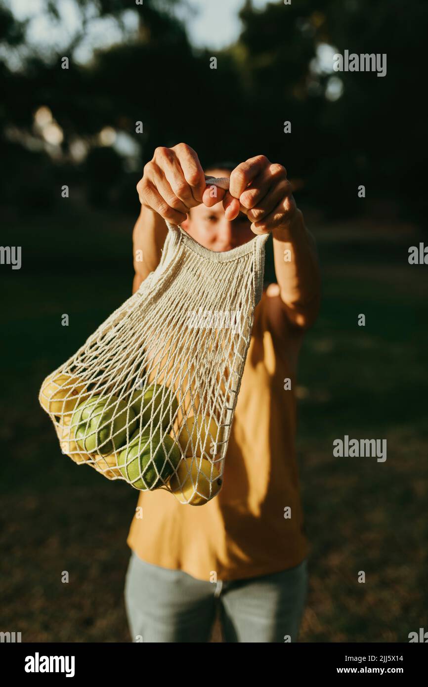 Frau hält Früchte in einem Netzbeutel Stockfoto