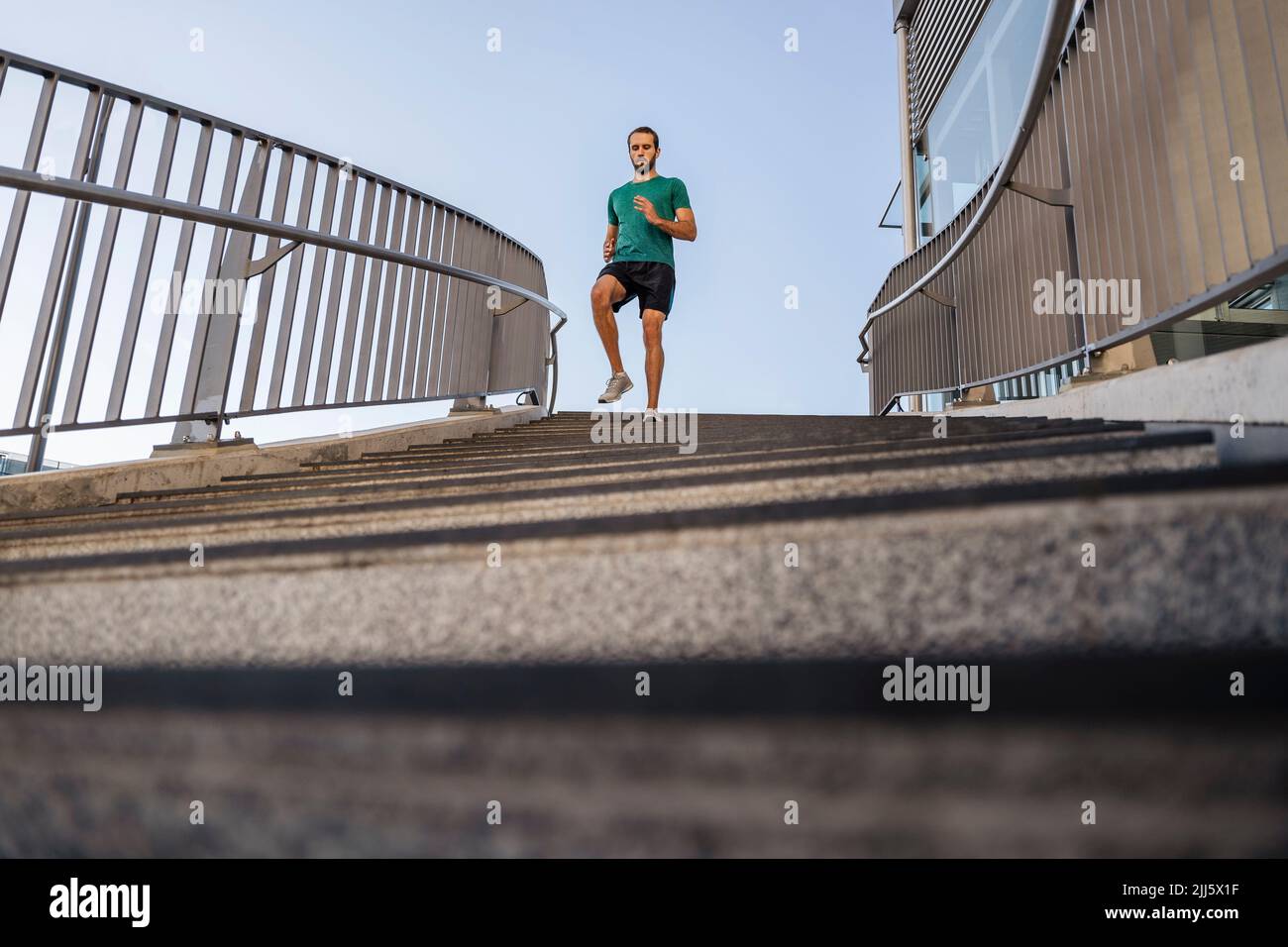 Junger Mann, der auf der Treppe läuft Stockfoto