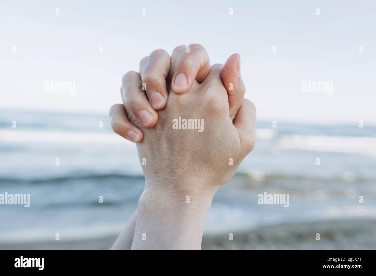 Die Hände klatschten am Strand vor dem Meer Stockfoto
