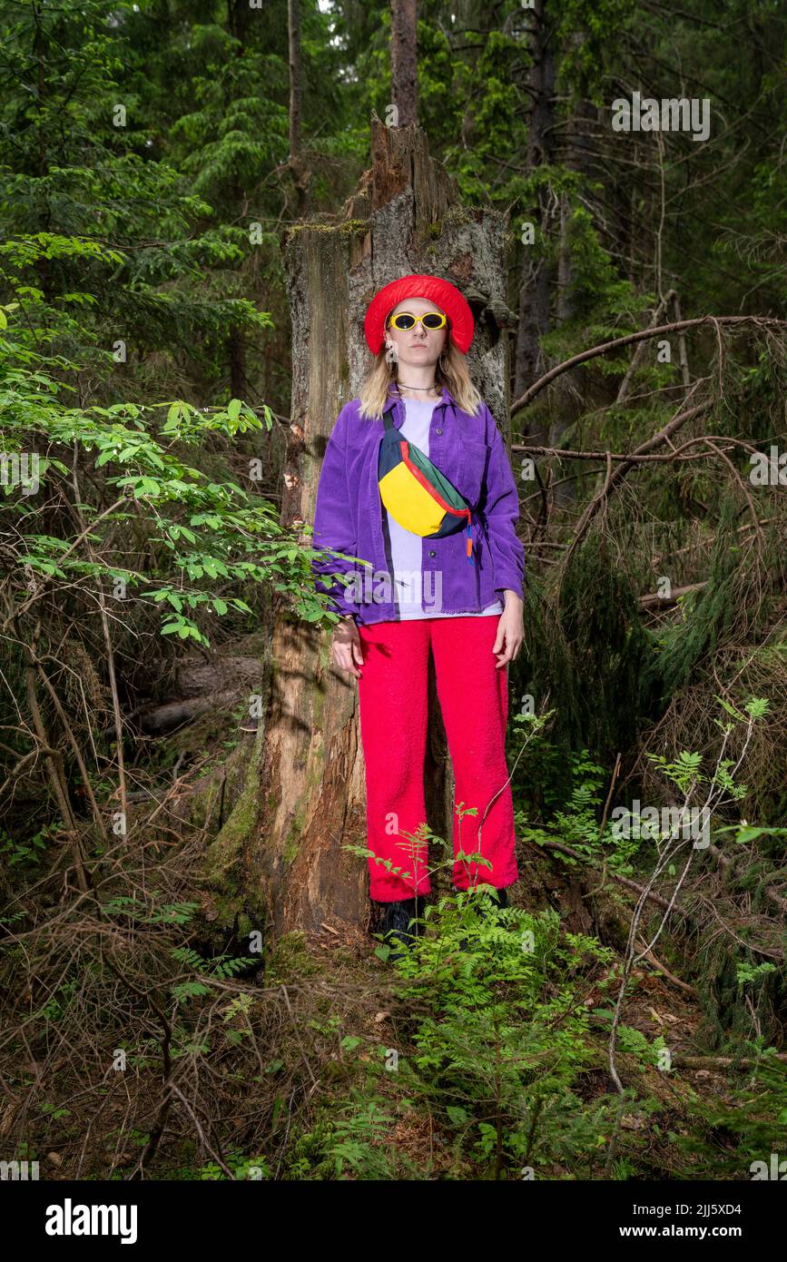 Frau, die vor einem beschädigten Baumstamm steht Stockfoto