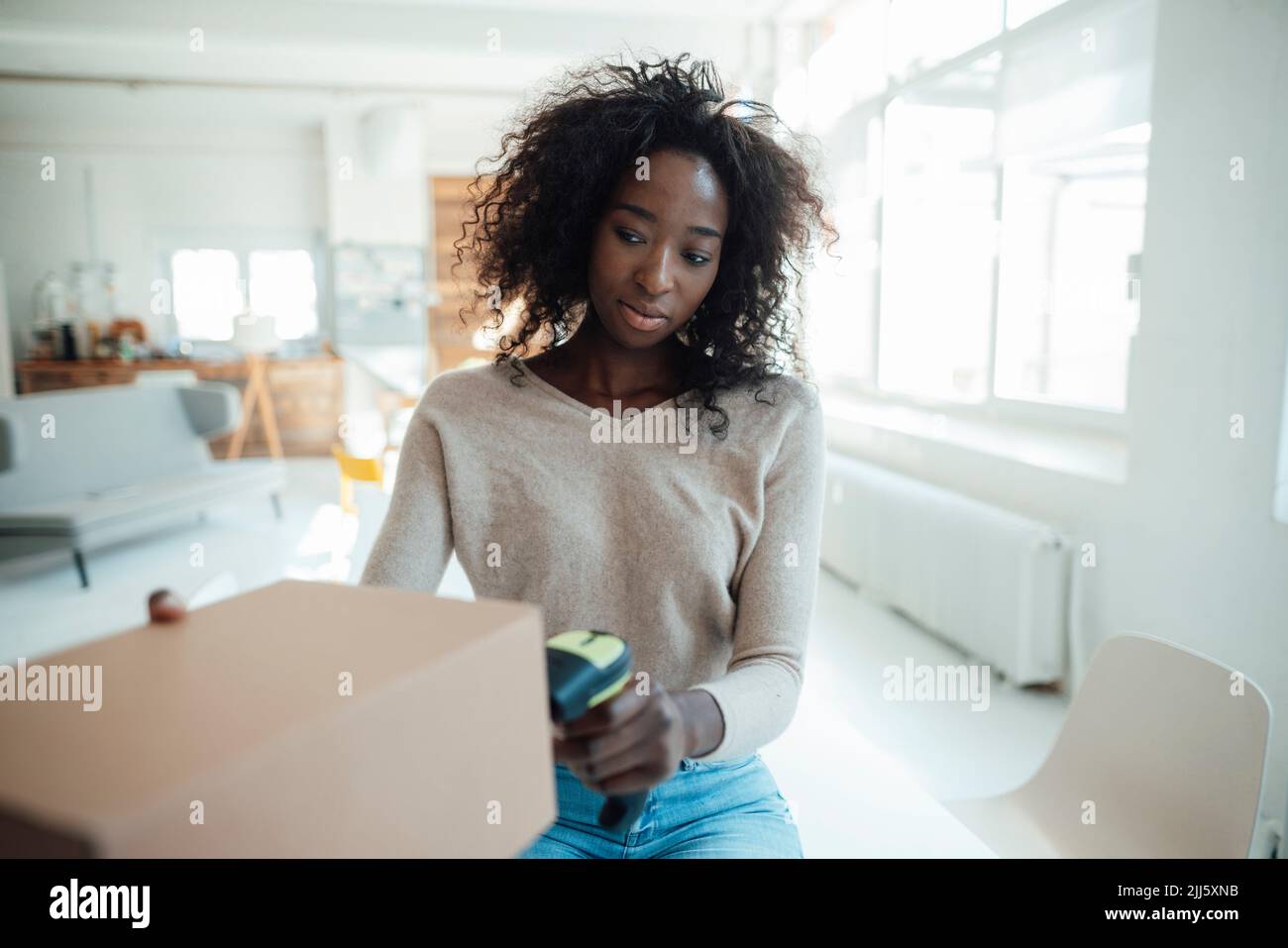 Geschäftsfrau scannt Barcode auf Karton Stockfoto