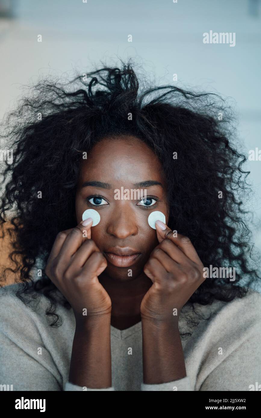 Junge Frau, die Papier vor ihren Augen hält Stockfoto