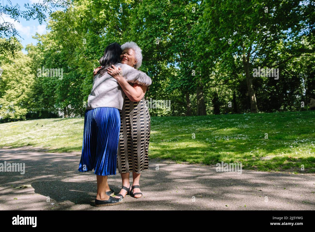 Mutter umarmt Tochter im park Stockfoto