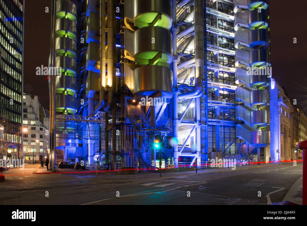 Lloyds of London erleuchtete nachts, einschließlich der roten Bremsleuchten eines vorbeifahrenden Autos Stockfoto