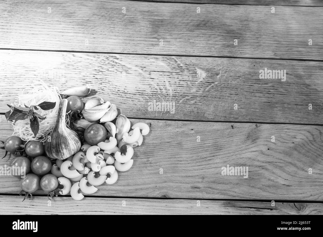 Pasta-Zutaten auf Holztisch. Kirschtomate, Zwiebeln, Knoblauch Stockfoto