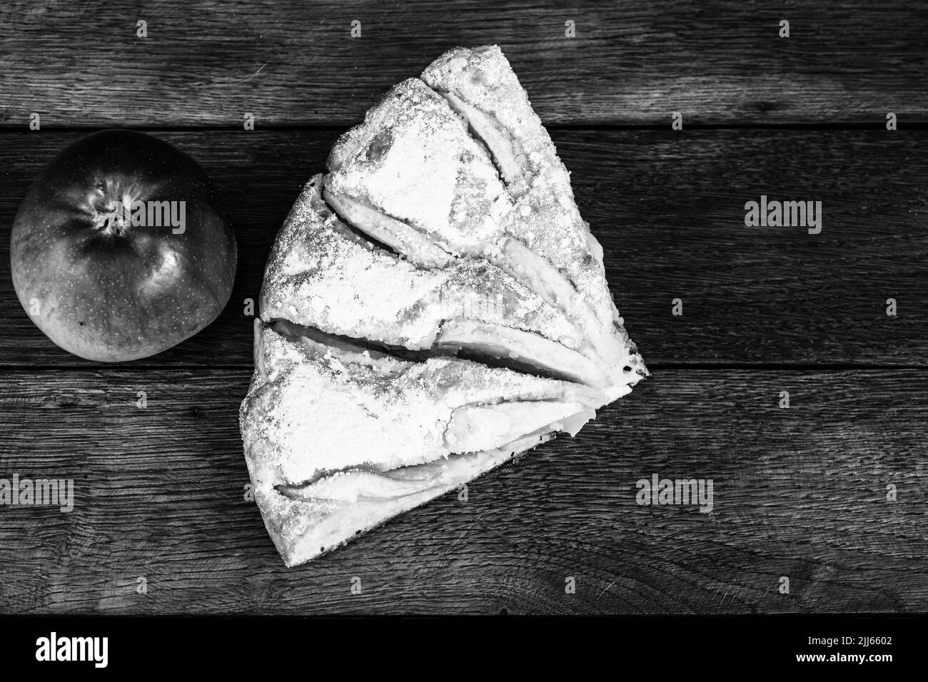 Scheiben von frisch gebackenen Apfelkuchen mit Zucker Pulver und roter Apfel auf einem Holzbrett. Hausgemachte Apfelkuchen. Stockfoto