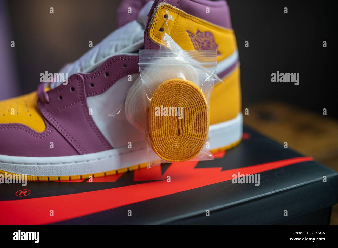 Eine Nahaufnahme von orange-lila Retro Jordan 1 Schuhen mit farbigen Schnürsenkeln Stockfoto