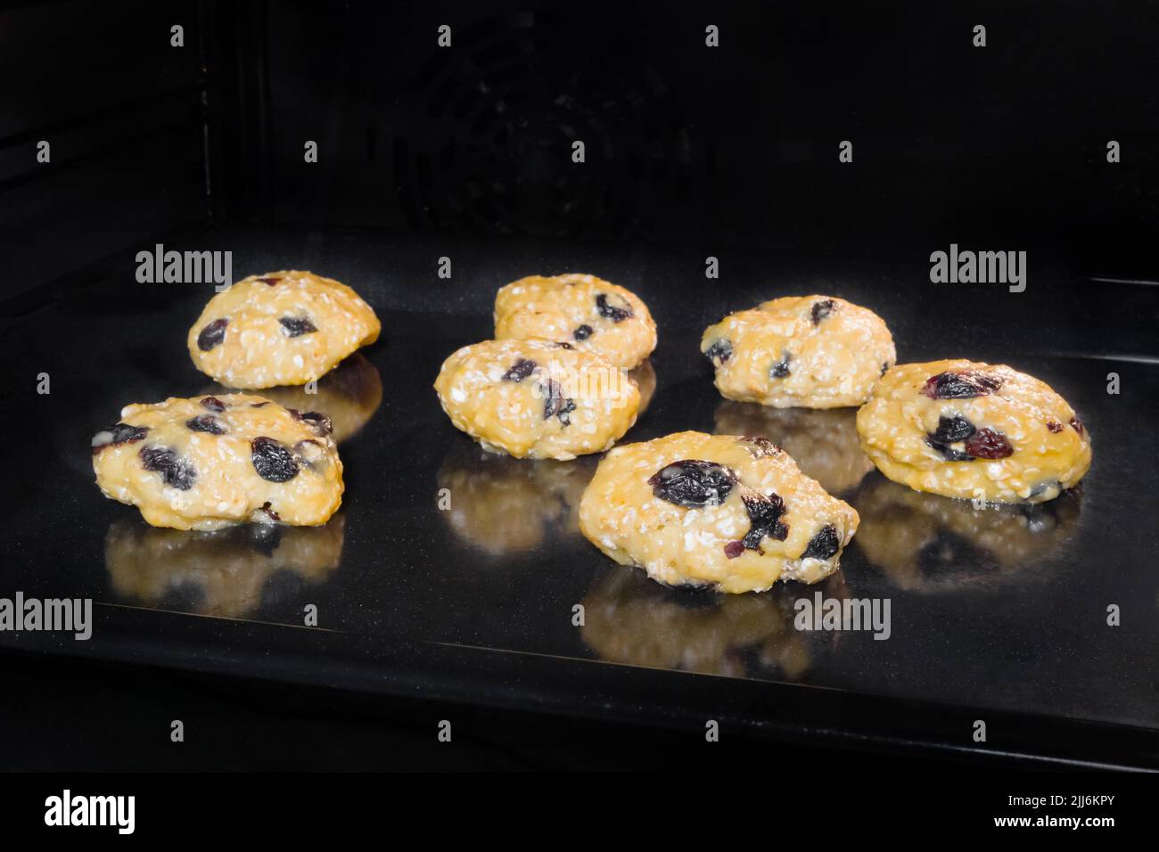 Sieben rosinierte Haferflocken Rosinenplätzchen auf Metallblech im Ofen Stockfoto