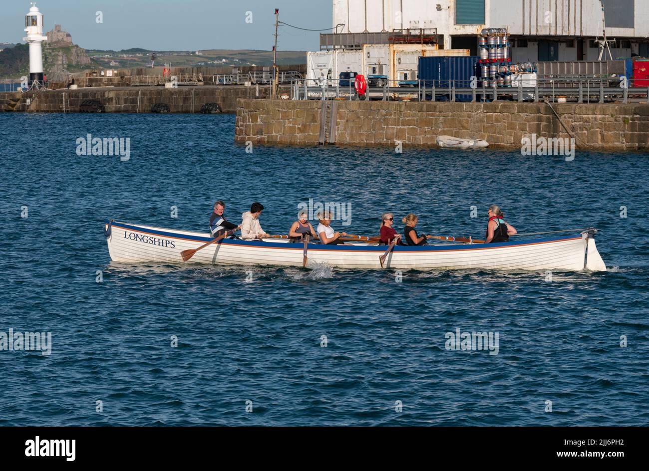 Penzance, Cornwall, England, Großbritannien. 2022. The Longships ein Training Pilot Gig und Crew rudern auf Penzance Harbour, Cornwall, UK Stockfoto