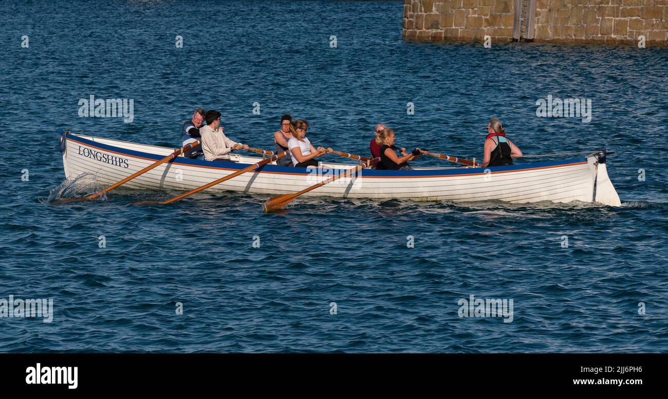 Penzance, Cornwall, England, Großbritannien. 2022. The Longships ein Training Pilot Gig und Crew rudern auf Penzance Harbour, Cornwall, UK Stockfoto