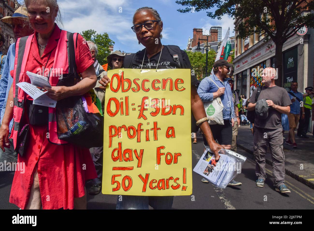 London, Großbritannien. 23.. Juli 2022. Ein Protestler hält ein Plakat, auf dem steht, dass die Ölkonzerne während der Demonstration in Bloomsbury seit 50 Jahren täglich £3 Milliarden Gewinne erwirtschaftet haben. Protestierende von Just Stop Oil, Extinction Rebellion, Isolate Britain und anderen Gruppen marschierten durch das Zentrum Londons und forderten die Regierung auf, fossile Brennstoffe zu beenden, große Umweltverschmutzer und Milliardäre zu besteuern, alle Häuser zu isolieren und gegen die Klima- und Lebenshaltungskrise zu handeln. (Foto: Vuk Valcic/SOPA Images/Sipa USA) Quelle: SIPA USA/Alamy Live News Stockfoto
