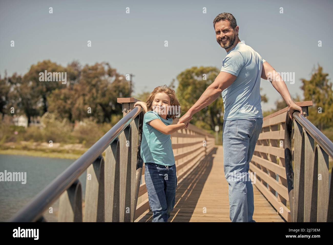 Glücklicher Vater, der Spaß mit seinem Sohn hat, der im Sommer draußen läuft Stockfoto