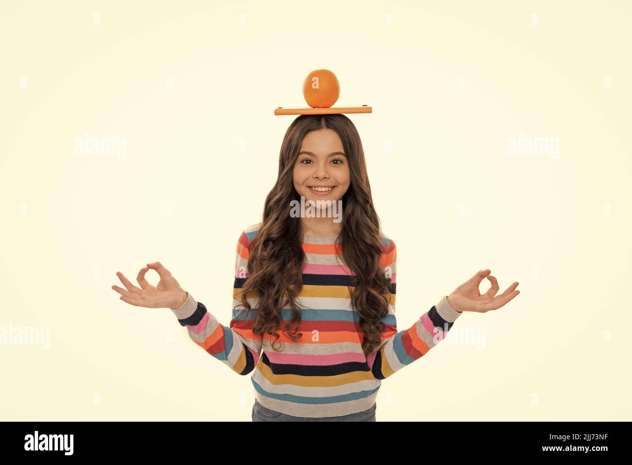 Zurück zur Schule. Wissen. Kind meditieren. Yoga. Glückliches Mädchen mit Orange und Schulnotizbuch Stockfoto