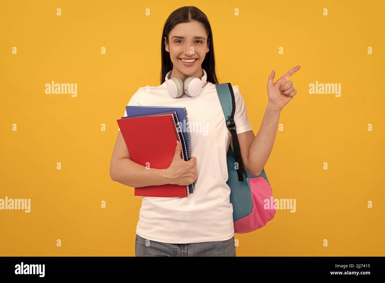 Glückliches Mädchen hält Notizbuch auf gelb b auf Kopie Spaceackground. Private Lehrer Stockfoto