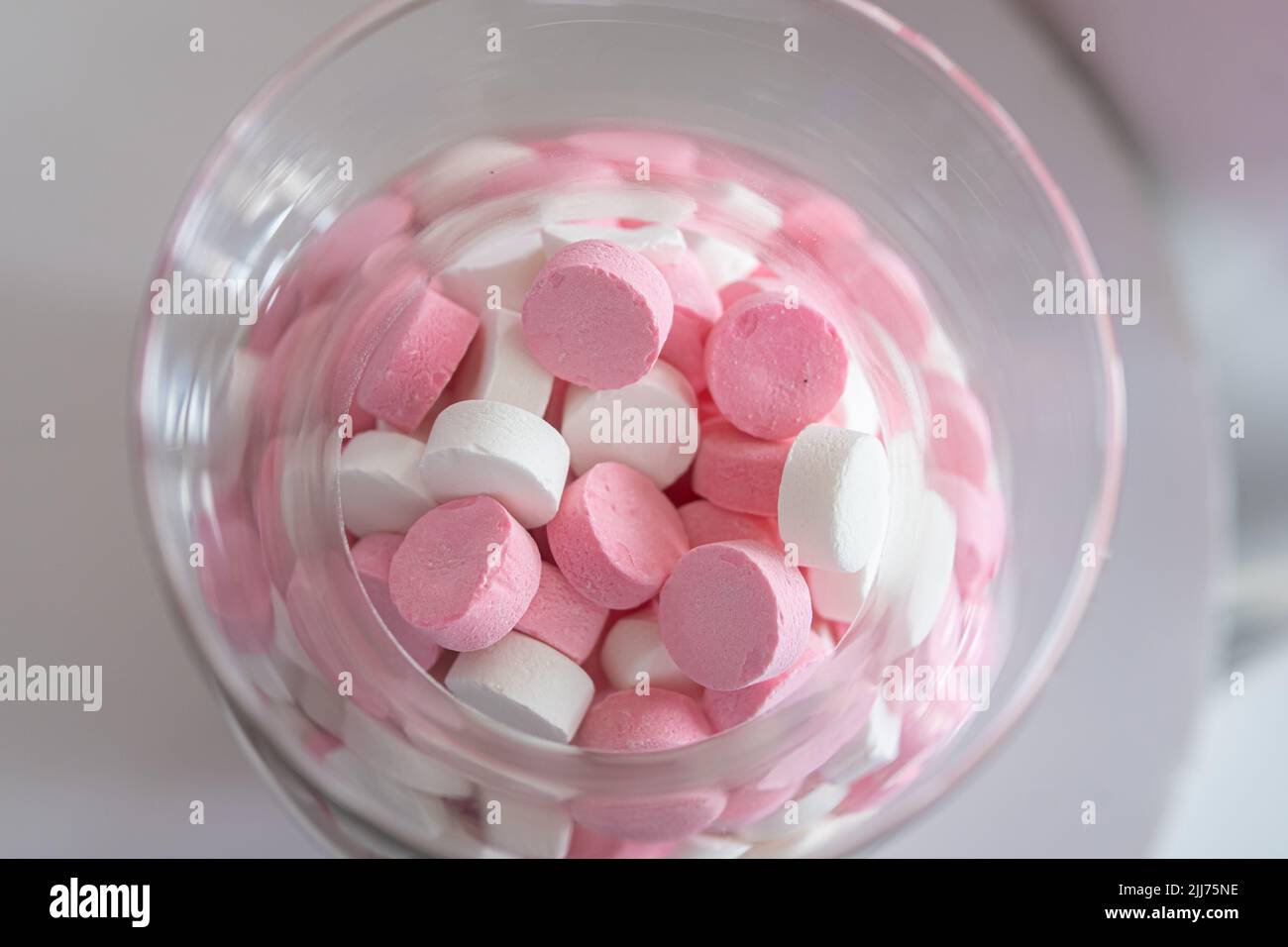 Rosa und weiße Süßigkeiten in einem Glas Stockfoto