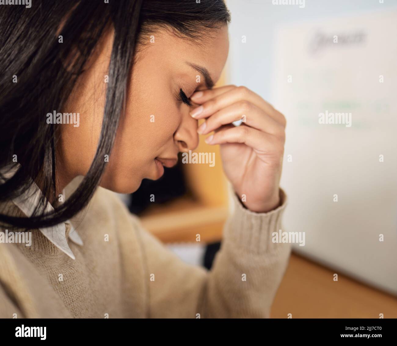 Ich habe eine harte Zeit. Eine schöne junge Frau, die gestresst aussieht, während sie zu Hause sitzt. Stockfoto